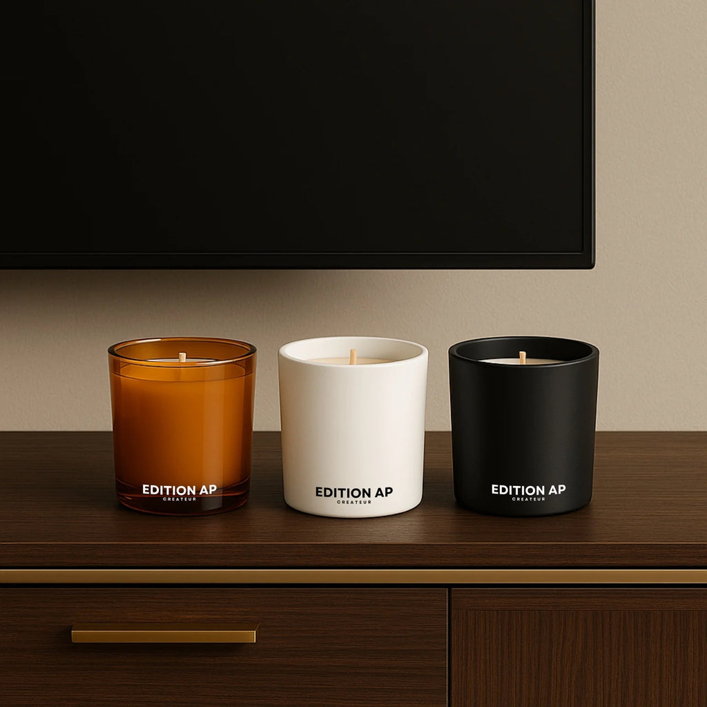 Trio_de_bougies_parfumees_Edition_AP_en_blanc_mat_noir_mat_et_verre_ambre_alignees_sur_meuble_luxueux